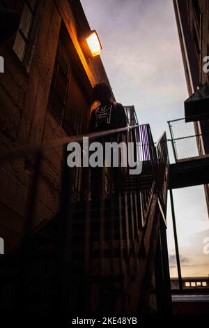 Un colpo verticale di un uomo che scende una scala Foto Stock