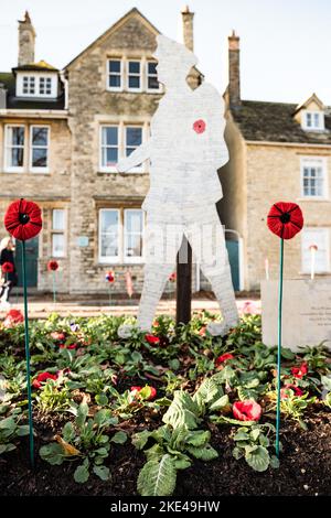 Papaveri di ceramica spinti nel terreno nel cimitero della Chiesa di Santa Maria, Witney per la Giornata della memoria Foto Stock