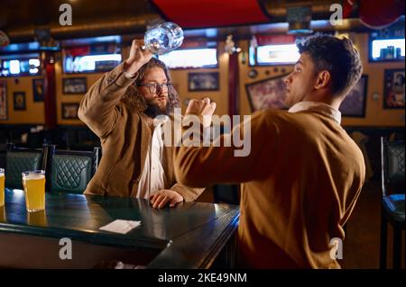 Infelici uomini che combattono al pub Foto Stock