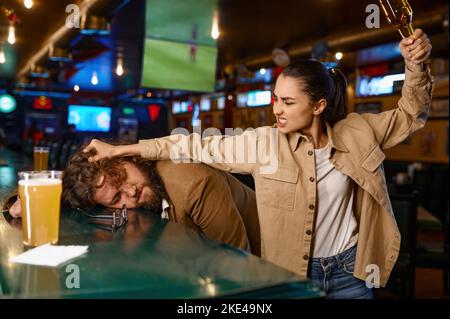 Tifosi infelici e arrabbiati che combattono allo sport bar Foto Stock