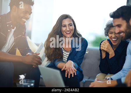 Questo è l'aspetto del brainstorming produttivo. Un team di imprenditori creativi che si occupano di brainstorming intorno a un notebook in ufficio. Foto Stock