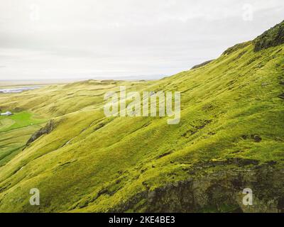 Paesaggio islandese con colline verdi e vivaci, ripresa aerea drone Foto Stock