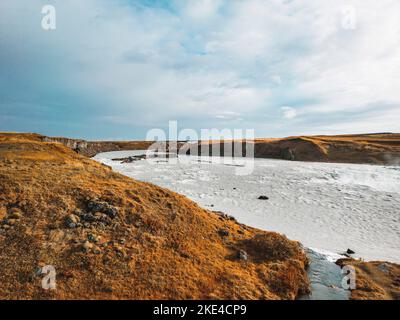 Colline coperte di erba e fiume blu brillante Foto Stock