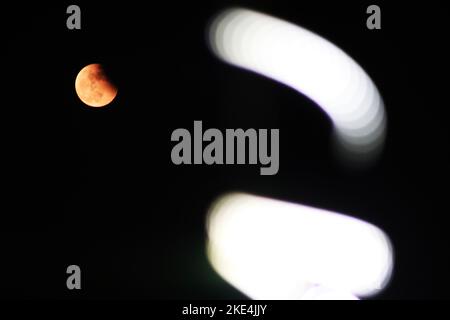 Kolkata, Bengala Occidentale, India. 8th Nov 2022. La "Luna del sangue" è vista dietro una luce stradale durante un'eclissi lunare totale a Kolkata il 8 novembre 2022. (Credit Image: © Dipa Chakraorty/Pacific Press via ZUMA Press Wire) Foto Stock