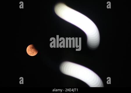 Kolkata, Bengala Occidentale, India. 8th Nov 2022. La "Luna del sangue" è vista dietro una luce stradale durante un'eclissi lunare totale a Kolkata il 8 novembre 2022. (Credit Image: © Dipa Chakraorty/Pacific Press via ZUMA Press Wire) Foto Stock