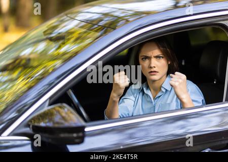 la donna arrabbiata in auto mostra il pugno Foto Stock