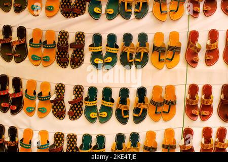 Coloratissime cappe fatte a mano (sandali) vendute in un mercato indiano, ciabatte in pelle fatte a mano, calzature tradizionali. Foto Stock