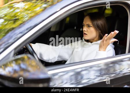 Orinato donna alla guida della vettura e gridava a qualcuno Foto Stock