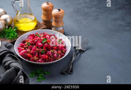 Insalata tradizionale vinaigrette su sfondo scuro. Insalata con verdure, piselli ed erbe fresche. Foto Stock