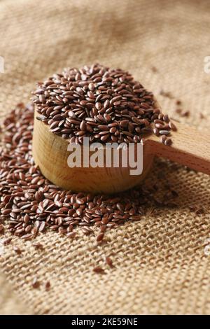 primo piano dei semi di lino sul cucchiaio di legno sul tavolo Foto Stock