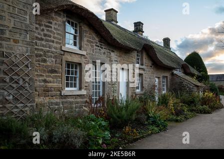 Una vecchia casa a due piani costruita in pietra con cottage in paglia sulla strada Foto Stock