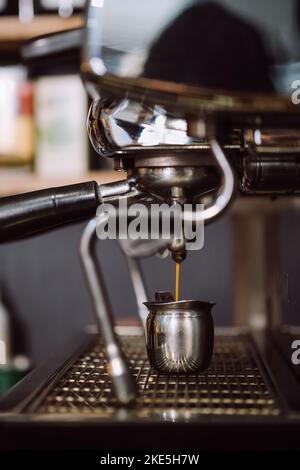 Primo piano per preparare il caffè caldo con la macchina per il caffè in una tazza. Bevanda per la prima colazione. Espresso Crema Perfect shot dalla macchina per caffè. Seleziona Foto Stock