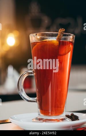 Primo piano di natale VIN brulé con spezie e frutta a tavola sullo sfondo calda luce gialla in camera. Bevanda calda tradizionale al periodo natalizio. HAP Foto Stock
