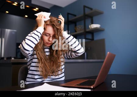 Donna stressata calcola le spese sulle fatture, turbato circa i prezzi aumentati delle utenze. Riceventi di contabilità femminile, assegni di reddito, debiti, prestiti a. Foto Stock