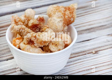 Crosta di maiale o crackling perfettamente croccanti in ciotola bianca con spazio copia Foto Stock