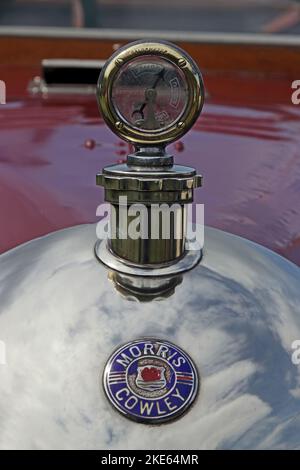 Indicatore della temperatura dell'acqua e badge Morris Cowley del 1920 sul radiatore a punta tonda Foto Stock