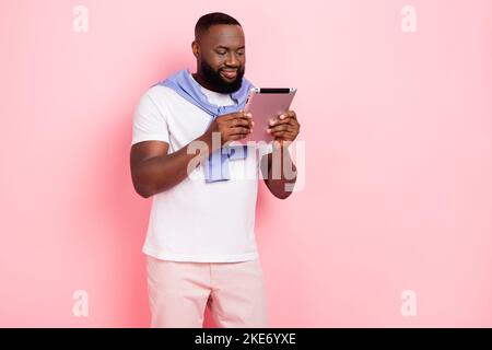 Foto di un giovane uomo d'affari intelligente e di successo occupato con i rapporti utilizzare tablet isolato su sfondo di colore rosa Foto Stock