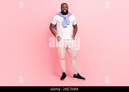 Immagine a corpo pieno di giovane uomo ben guardante in attesa della sua ragazza isolata su sfondo di colore rosa Foto Stock