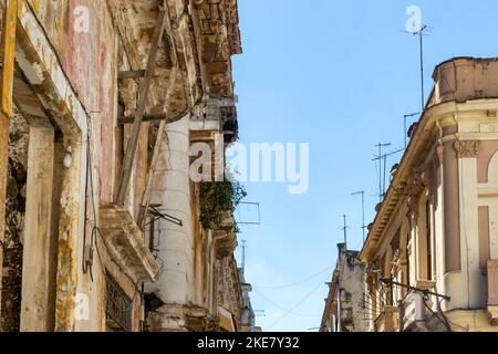 Un edificio dalla facciata crollata e fatiscente. Sul lato destro, antenne tv sulla parte superiore dei tetti dell'edificio. Foto Stock