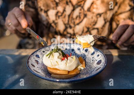 Lady tenendo coltello e forchetta mentre mangia il suo pranzo da vicino Foto Stock