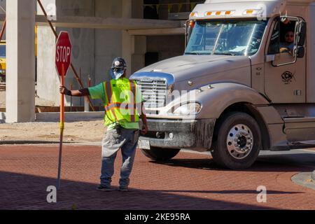 Flagger tenendo il cartello di stop in cantiere. Foto Stock