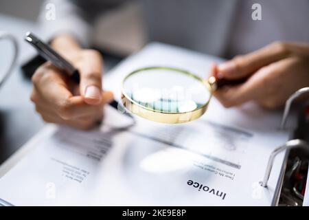Revisore che utilizza la lente di ingrandimento per l'audit e l'indagine sulle frodi Foto Stock