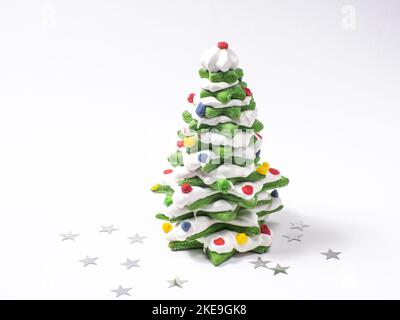Albero di natale di biscotto verde fatto da taglierina di biscotto della stella su fondo bianco Foto Stock