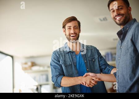 Insieme, stiamo facendo le cose accadere. Ritratto di due uomini d'affari che scuotono le mani in piedi in ufficio. Foto Stock