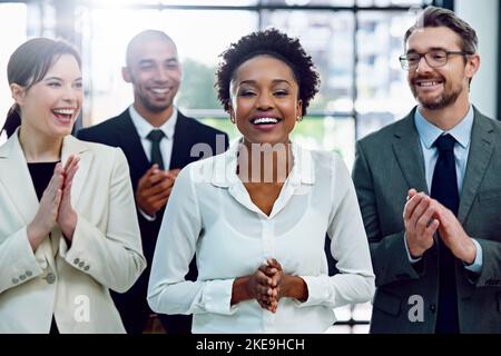 Il riconoscimento è la ricompensa per il duro lavoro. Ritratto di una donna d'affari di successo applaudita dai suoi colleghi in ufficio. Foto Stock