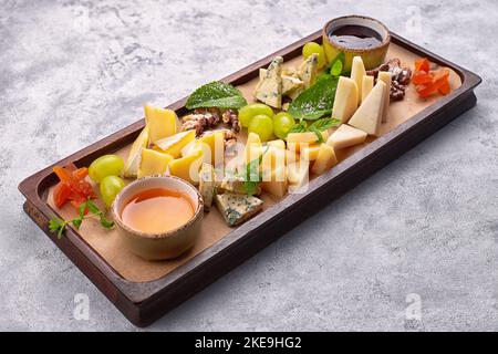 Formaggi assortiti con noci, albicocche secche e uva Foto Stock