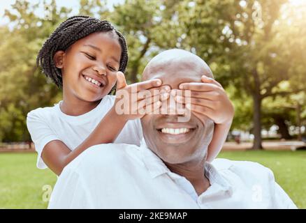 Parco, sorpresa e ragazza con papà felice, mani sopra gli occhi e giocare al pic-nic in giardino. Natura, amore e famiglia, bambino e uomo nero su erba Foto Stock