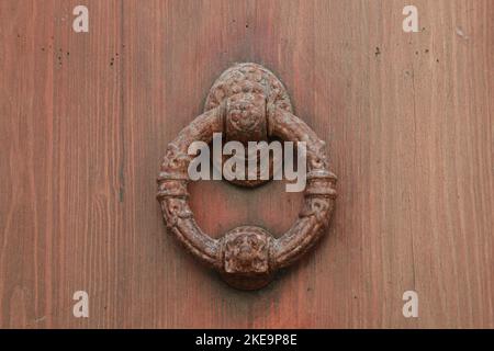 Ferro anello a forma di porta knoccker su Old porta di legno in Alcudia Spagna. Pomello porta a forma di anello Foto Stock