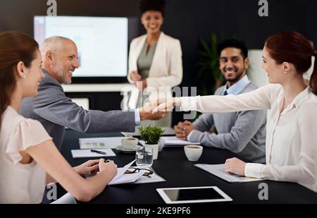 Successo nella realizzazione. Uomini d'affari che scuotono le mani durante una riunione in un ufficio moderno. Foto Stock