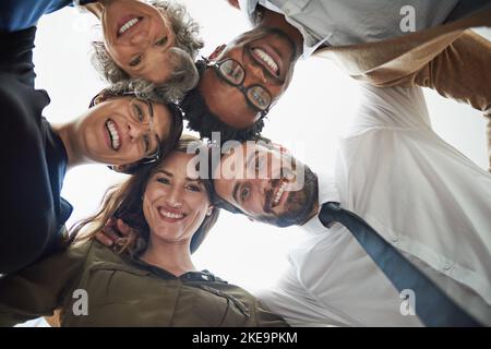 Theyre sempre felice di mettere le loro teste insieme. Ritratto ritagliato di un gruppo eterogeneo di uomini d'affari mettendo le loro teste insieme in una huddle. Foto Stock