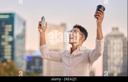 Successo, celebrazione e uomo con il telefono in città per il commercio di affari e vincere il gioco online a Singapore. Vincitore, motivazione e felice Foto Stock