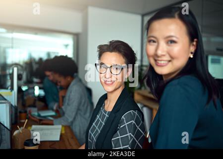 Il meglio dell'azienda. Ritratto ritagliato di due giovani designer che lavorano in ufficio. Foto Stock