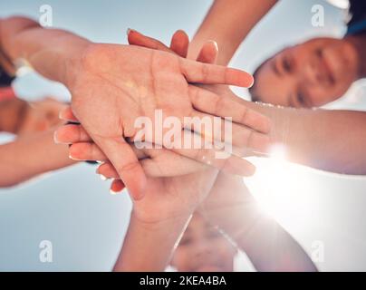 Mani, lavoro di squadra e collaborazione di amici, comunità o persone insieme per beneficenza, sostegno e motivazione all'aperto con il flare delle lenti. Raggruppa insieme Foto Stock