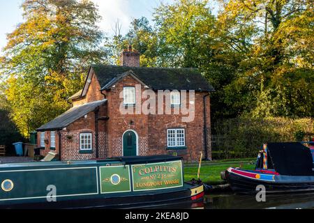 Vecchie barche a remi di canale funzionanti da Longport Wharf ormeggiate sul canale Shropshire Union all'esterno di un cottage canale a Nantwich Cheshire Foto Stock