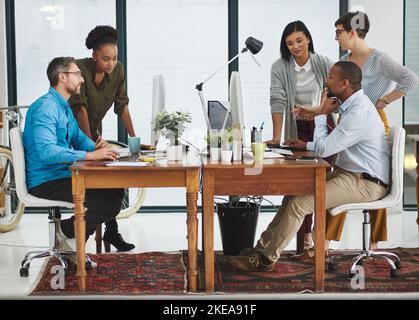 Una giornata ordinaria in ufficio. Immagine completa di un gruppo di colleghi che lavorano nel loro ufficio. Foto Stock