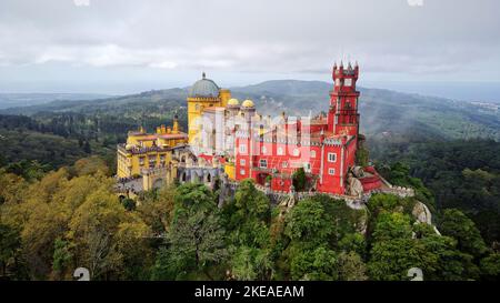 Vista aerea del parco e del Palazzo Nazionale di pena a Sintra, Portogallo, durante una giornata magica. UNESCO. Visite storiche. Visite turistiche. Fiaba. Foto Stock