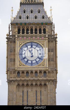 Il quadrante dell'orologio sulla Elizabeth Tower mostra le ore 11:00 mentre i membri del pubblico osservano un silenzio di due minuti in Parliament Square, Westminster, per ricordare i morti di guerra nel giorno dell'armistizio. Data immagine: Venerdì 11 novembre 2022. Foto Stock