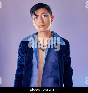 Uomo asiatico, trucco e punk moda per il ritratto in studio con cyberpunk, creativo o viso estetico. Modello futuristico, gioielli in metallo o vestiti Foto Stock