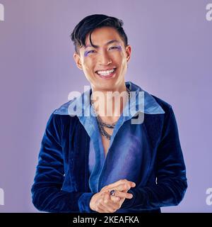 Moda, trucco punk e uomo asiatico in studio isolato su uno sfondo viola. Ritratto di bellezza, lgbtq e cyberpunk modello maschile dal Giappone con labbro Foto Stock
