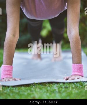 Yoga, mani e tappetino con una donna tavola closeup all'aperto in un parco erba per l'allenamento o l'allenamento. Benessere, salute e fitness con yoga femminile Foto Stock