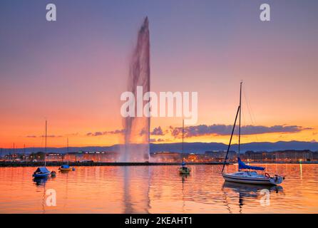 Jet d'eau, punto di riferimento del Lago di Ginevra al tramonto, passeggiata sul lago illuminato sullo sfondo, Svizzera, Kanton Genf Foto Stock