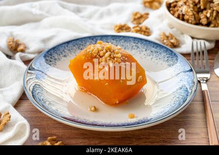 Dessert di zucca turca su pavimento in legno. Prelibatezze tradizionali della cucina turca. Nome locale kabak tatlisi. Primo piano Foto Stock