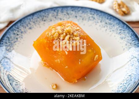 Dessert di zucca turca su pavimento in legno. Prelibatezze tradizionali della cucina turca. Nome locale kabak tatlisi. Primo piano Foto Stock