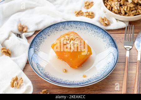 Dessert di zucca turca su pavimento in legno. Prelibatezze tradizionali della cucina turca. Nome locale kabak tatlisi. Primo piano Foto Stock