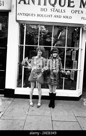 Londra negli anni '1960s. Birgitta Bjerke e Ulla Larsson al 251 di Kings Road di fronte alle bancarelle del mercato dell'antiquariato. Indossano la tipica moda 1960s del proprio design. Foto scattata durante l'era degli anni sessanta, una rivolta culturale guidata dai giovani nel Regno Unito dalla metà alla fine degli anni '1960s. Londra Inghilterra Ottobre 1967. Foto Stock