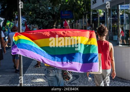 Salvador, Bahia, Brasile - 09 aprile 2022: I brasiliani protestano contro il candidato presidenziale di estrema destra Jair Bolsonaro. Utilizzano flag di movimento lgbt. Foto Stock